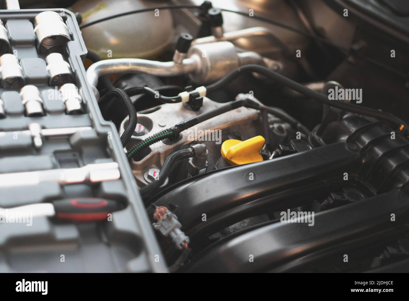 A set of socket wrenches lies on the car engine in the engine