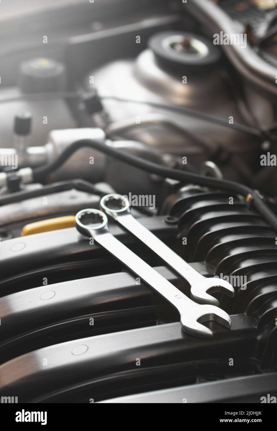 Wrenches for repairs lie on the car engine in the engine compartment