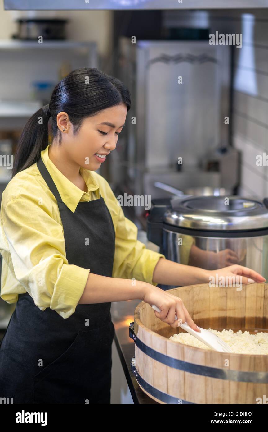 Woman standing near bowl preparing food in kitchen Stock Photo