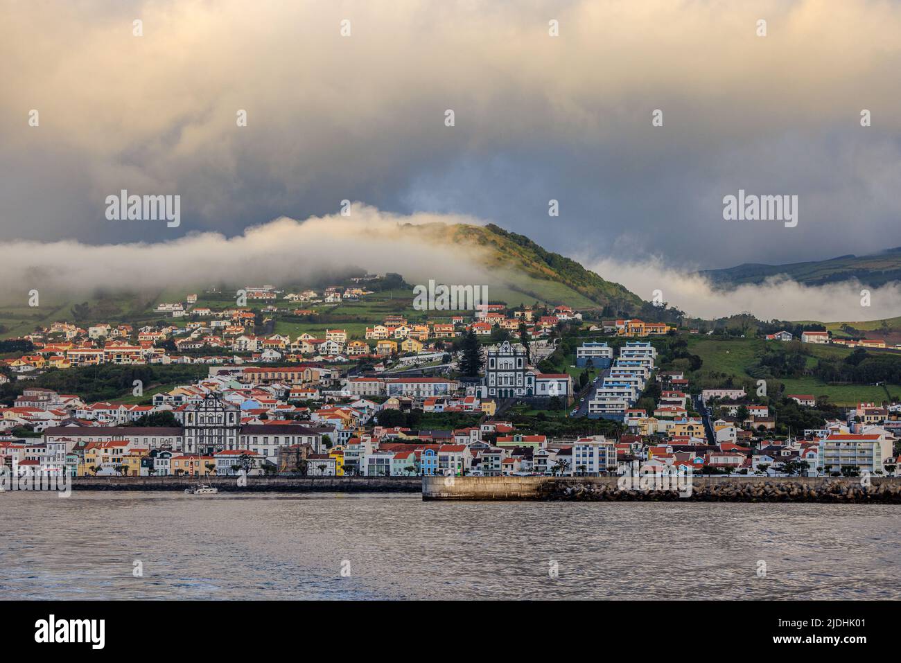 waterfront view of the harbour town of horta as low cloud sits on monte carneiro faial island Stock Photo