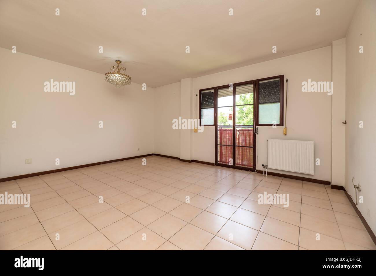 Empty room with square cream ceramic floor, dark red aluminum carpentry and aluminum radiators Stock Photo
