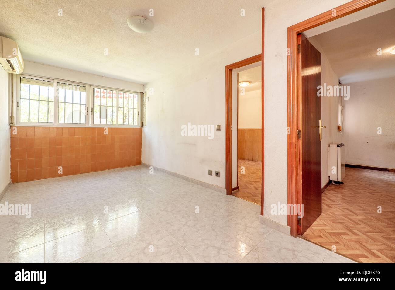 Empty room with access doors to other rooms with ceramic floors and a wall with brown tiles Stock Photo
