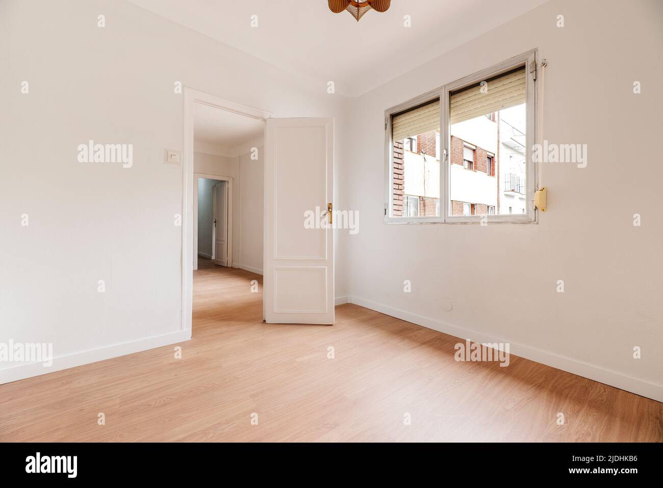 Empty living room with white painted walls with aluminum window, white carpentry, doors and lamps and light oak floor Stock Photo