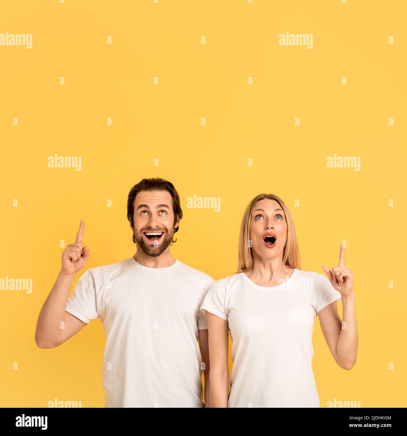 Cheerful shocked young caucasian man and woman in white tshirts with