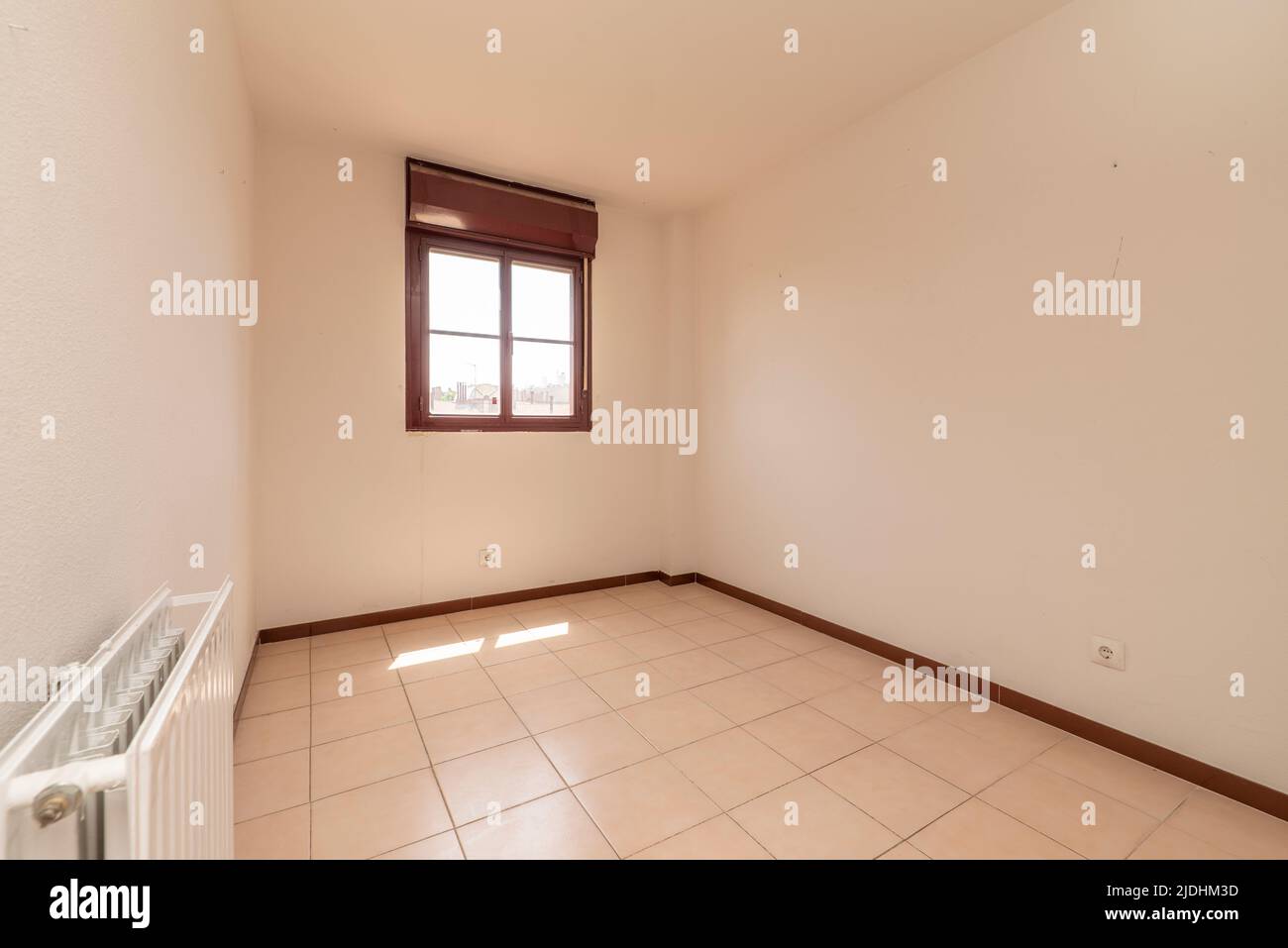 Empty room with square-format cream-colored ceramic stoneware floor, white-painted walls and red aluminum metal carpentry Stock Photo