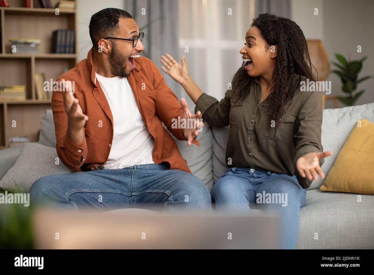 Excited Black Couple Celebrating Victory Shouting Watching Television At Home Stock Photo