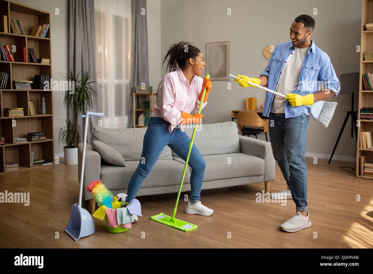 Black Couple Cleaning House Together Singing Having Fun At Home Stock Photo