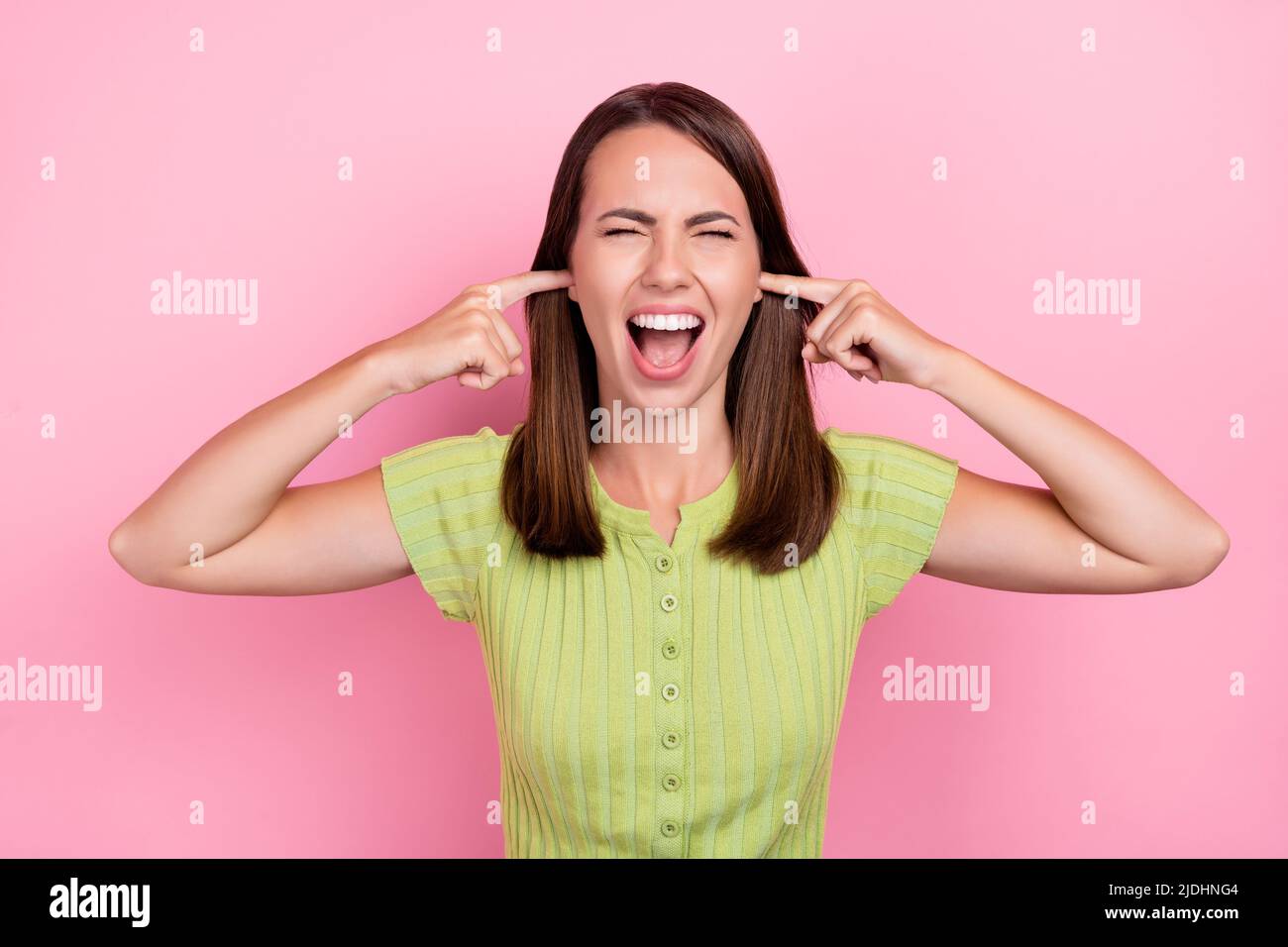 Photo of young girl cover ears fingers shout irritated mad crazy shirt top isolated over pink color background Stock Photo