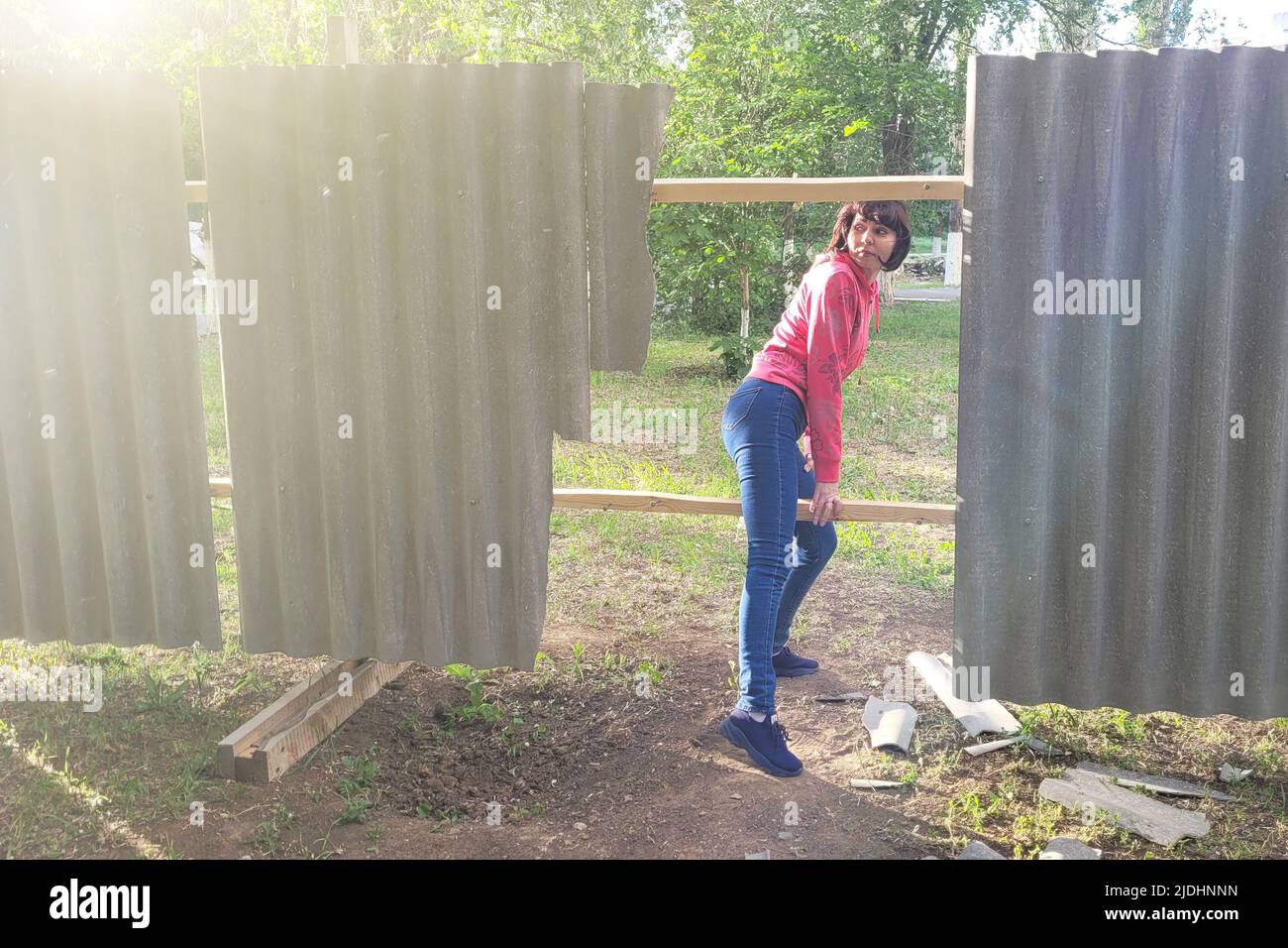 A woman climbs through a fence into a restricted area Stock Photo Alamy