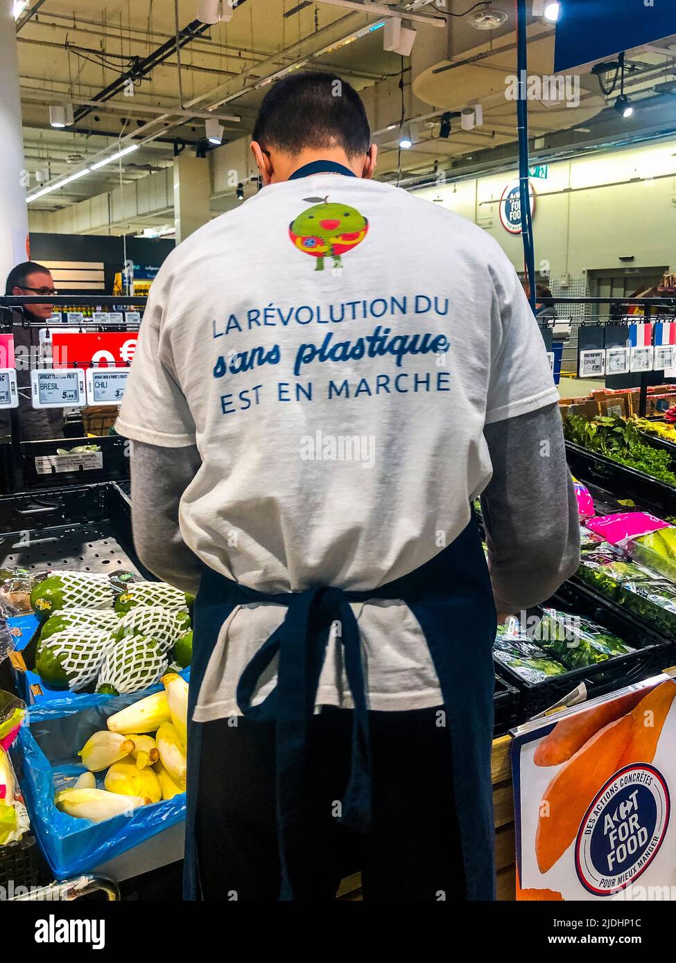 Paris, France, inside French Supermarket, Employee with T-Shirt Slogan 'The Revolution WIthout Plastic is in Action' (Carrefour) from behind, T shirt slogans Stock Photo
