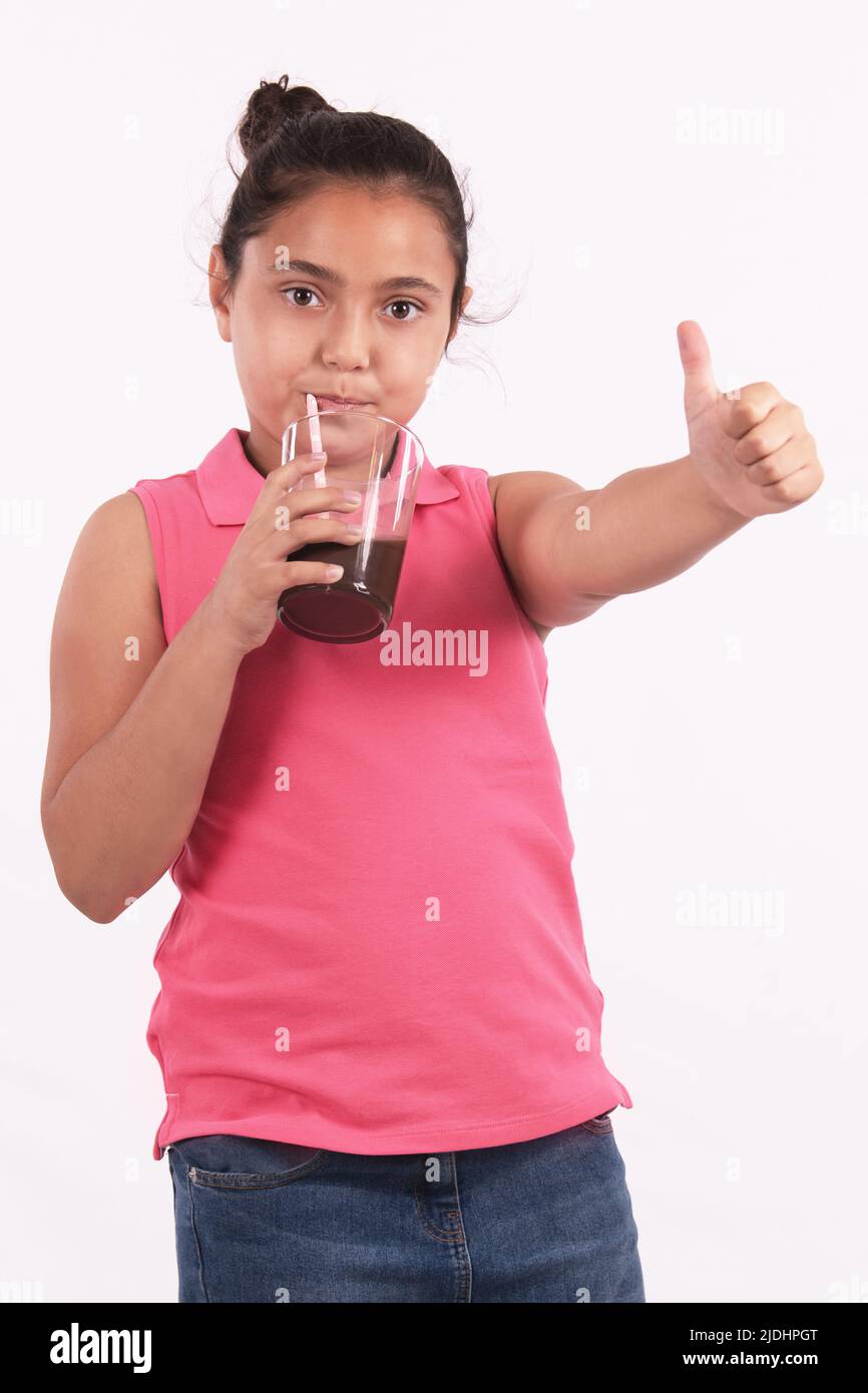 Portrait of a little girl drinking chocolate milk with a straw and