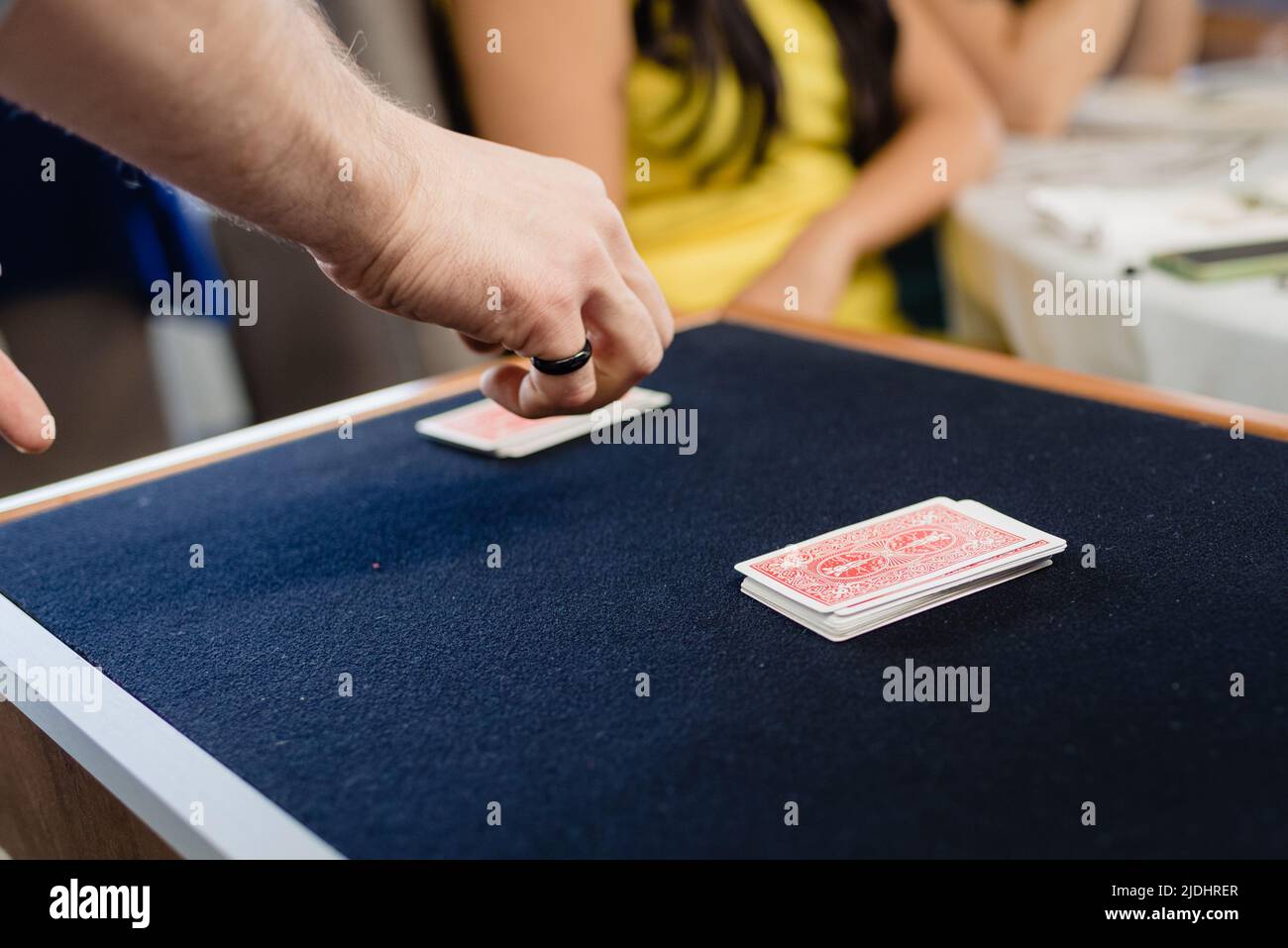A magician performs a trick with cards face down on a mat. Stock Photo