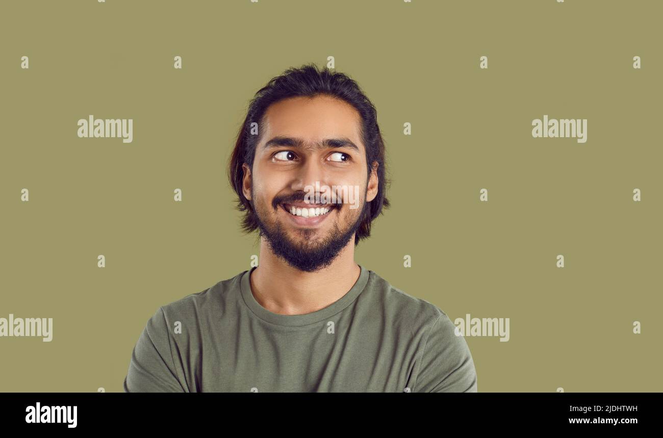 Portrait of young man feeling awkward and uncomfortable, looking sideways and smiling Stock Photo