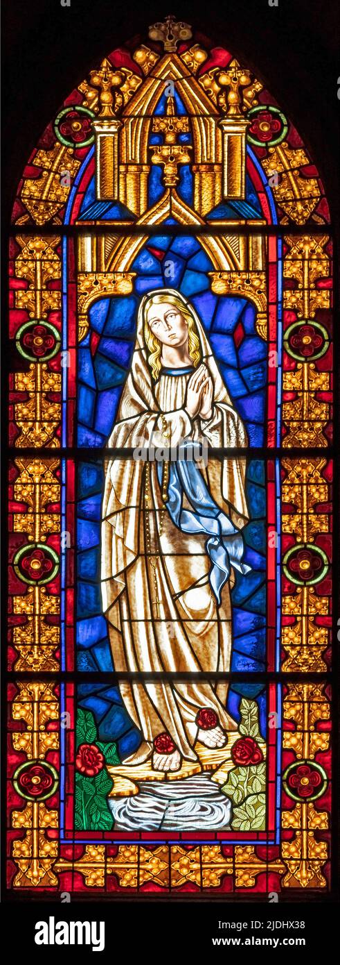 VALENCIA, SPAIN - FEBRUAR 16, 2022: The Virgin Mary of Lourdes on the stained glass of church Iglesia de Santa Catalina form 20. cent. Stock Photo