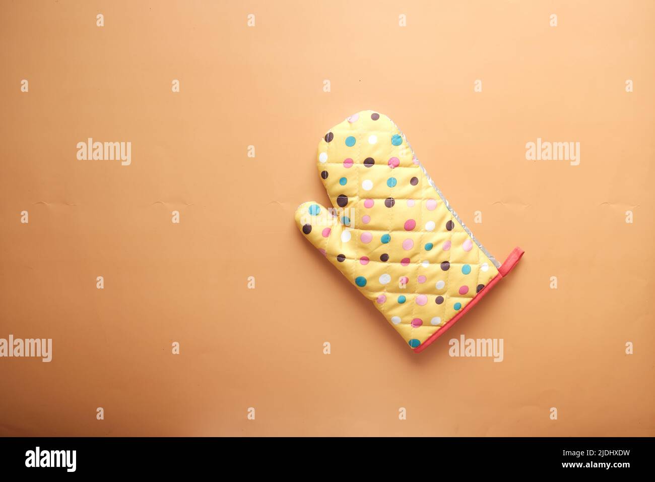 Kitchen gloves on orange background top down. Stock Photo