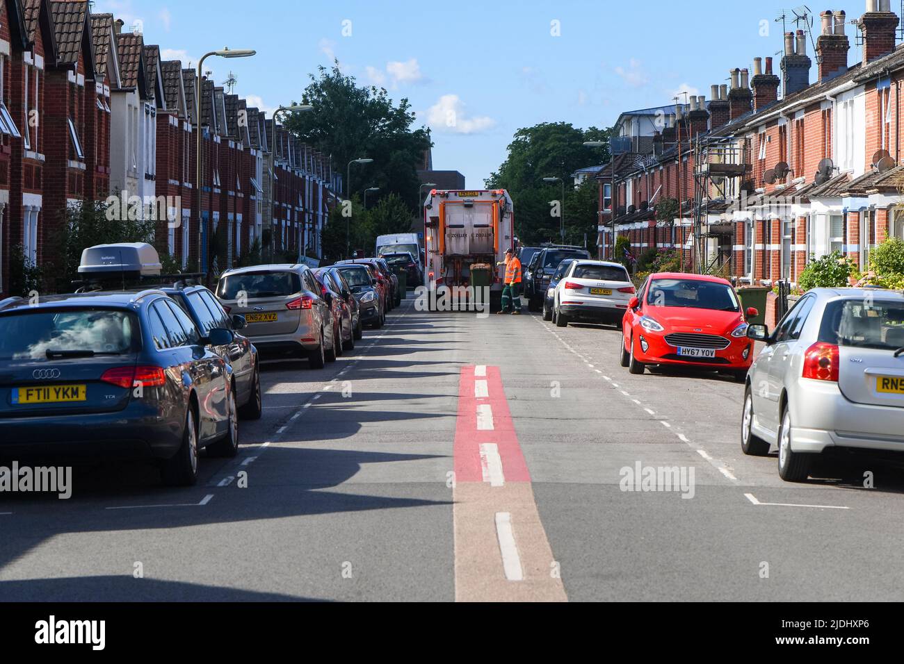 Refuge collectors block the road with the disposal truck as they collect waste from the narrow road of the town centre terrace houses of Eastleigh. Stock Photo