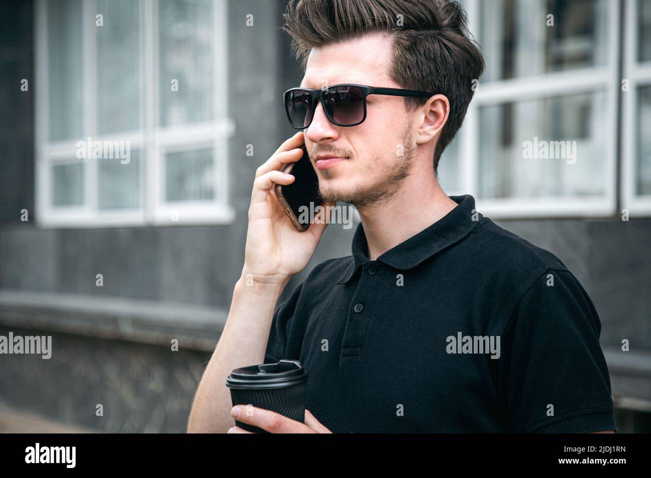 Young man in sunglasses is talking on a smartphone. Stock Photo