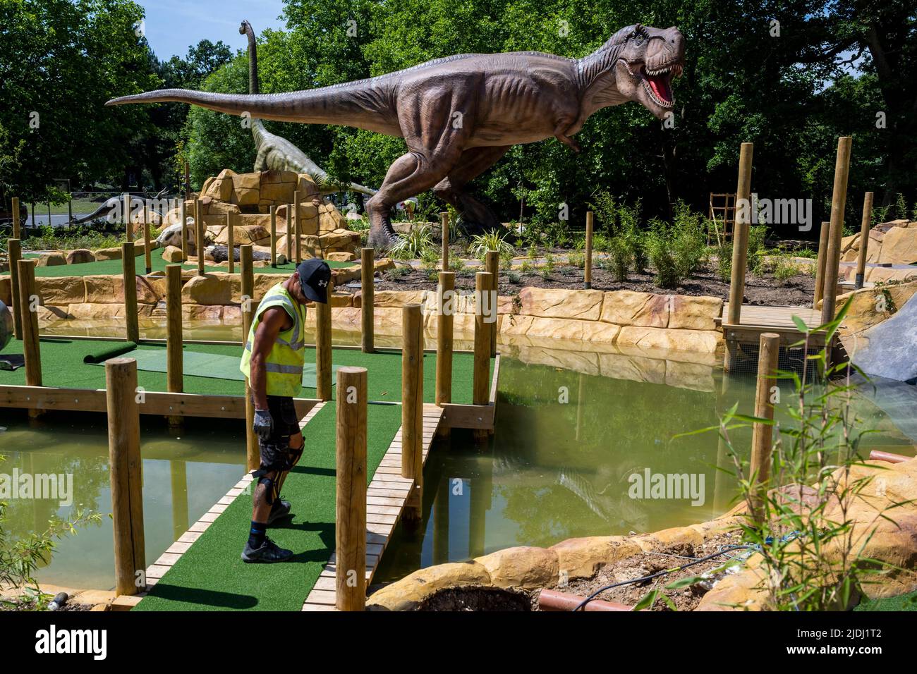 London, UK. 21 June 2022. Finishing touches are made to Jurassic Island, a  dinosaur-themed crazy golf course, being constructed in Harrow. Life-sized  dinosaurs are interspersed amongst the holes on the golf course