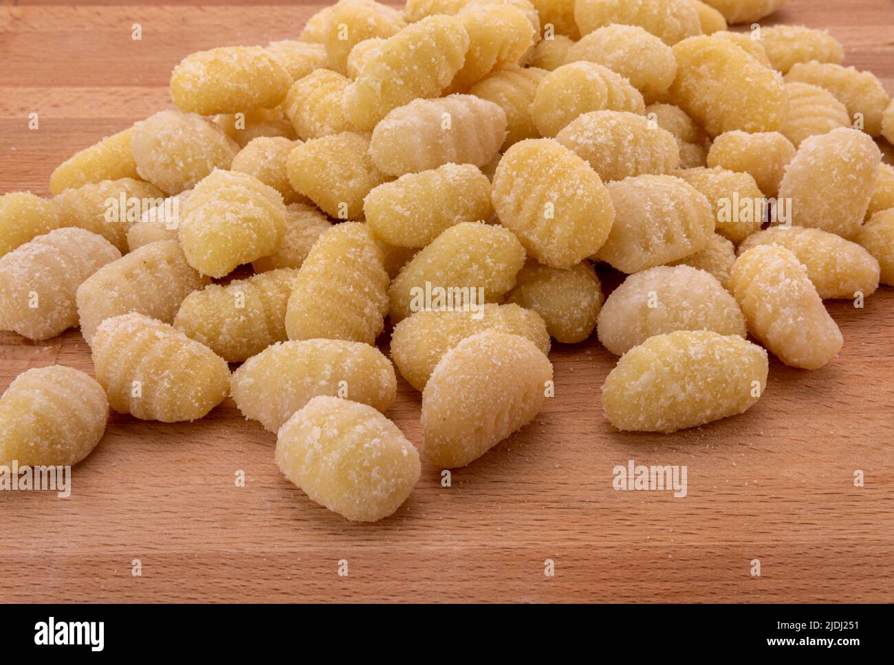 Potato gnocchi raw on wooden table, Italian pasta made with flour and potatoes. Uncooked dumplings Stock Photo