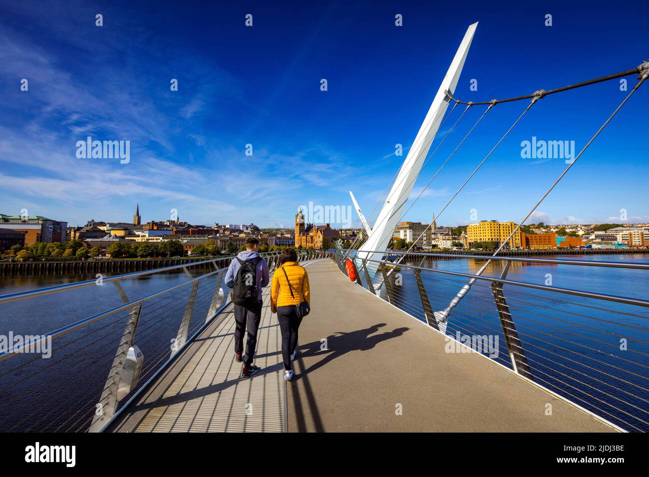 Couple crossing the Peace Bridge in Derry City, Northern Ireland Stock Photo