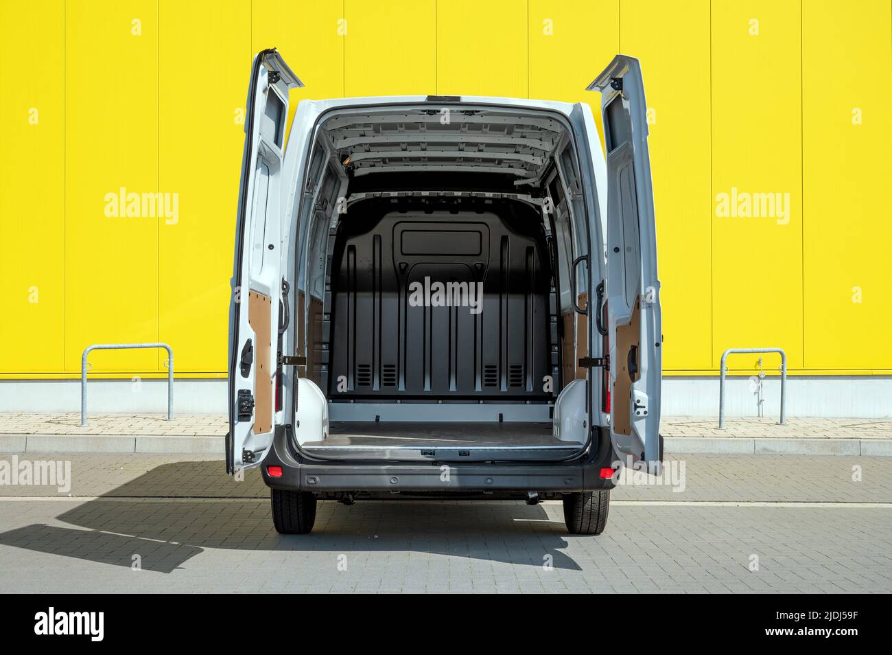 Empty van with open doors in front of a yellow wall Stock Photo - Alamy