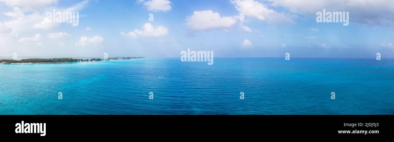 Super wide Panoramic image of North Bimini Island looking south with wide Atlantic ocean. Turquoise colored waters and tropical cloudscape  Vacation Stock Photo
