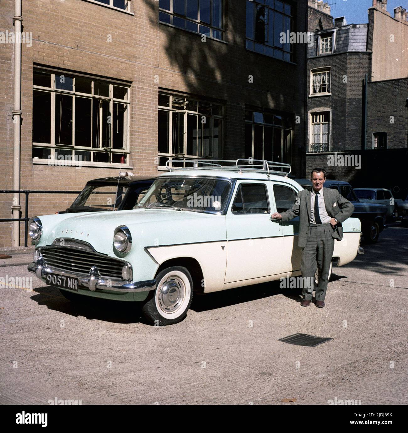 1964, historical, a gentleman in a suit & tie, proudly standing by his car of the era, a tone-tone, British Ford Zodiac, outside offices of Babcock & Wilcock Ltd, England, UK. Stock Photo
