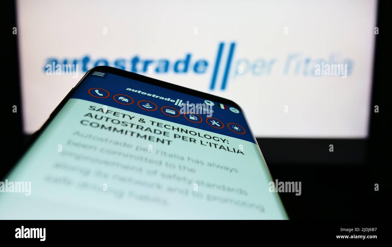Mobile phone with webpage of motorway company Autostrade per l'Italia S.p.A. on screen in front of logo. Focus on top-left of phone display. Stock Photo