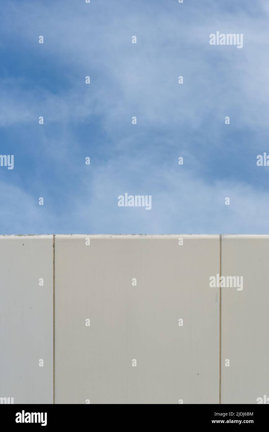 Abstract image, the corner of a modern building contrasting with the blue sky and soft white clouds. Stock Photo