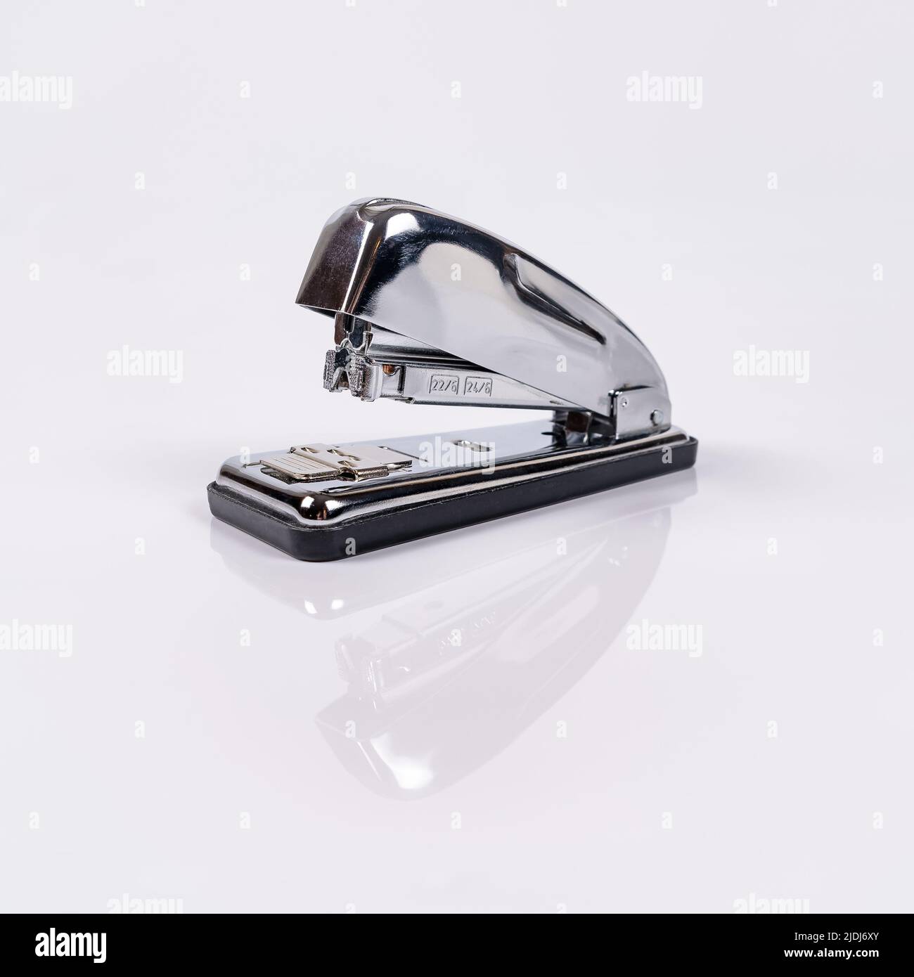 Metallic stapler for stapling sheets of paper with reflection on white