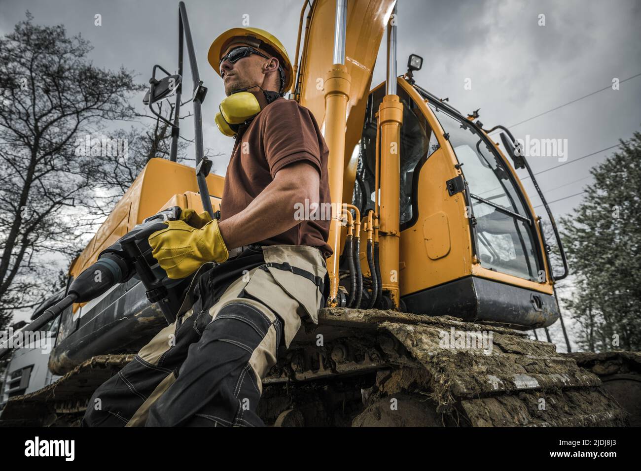 Caucasian Construction Worker in His 40s Proudly Holding a Jackhammer