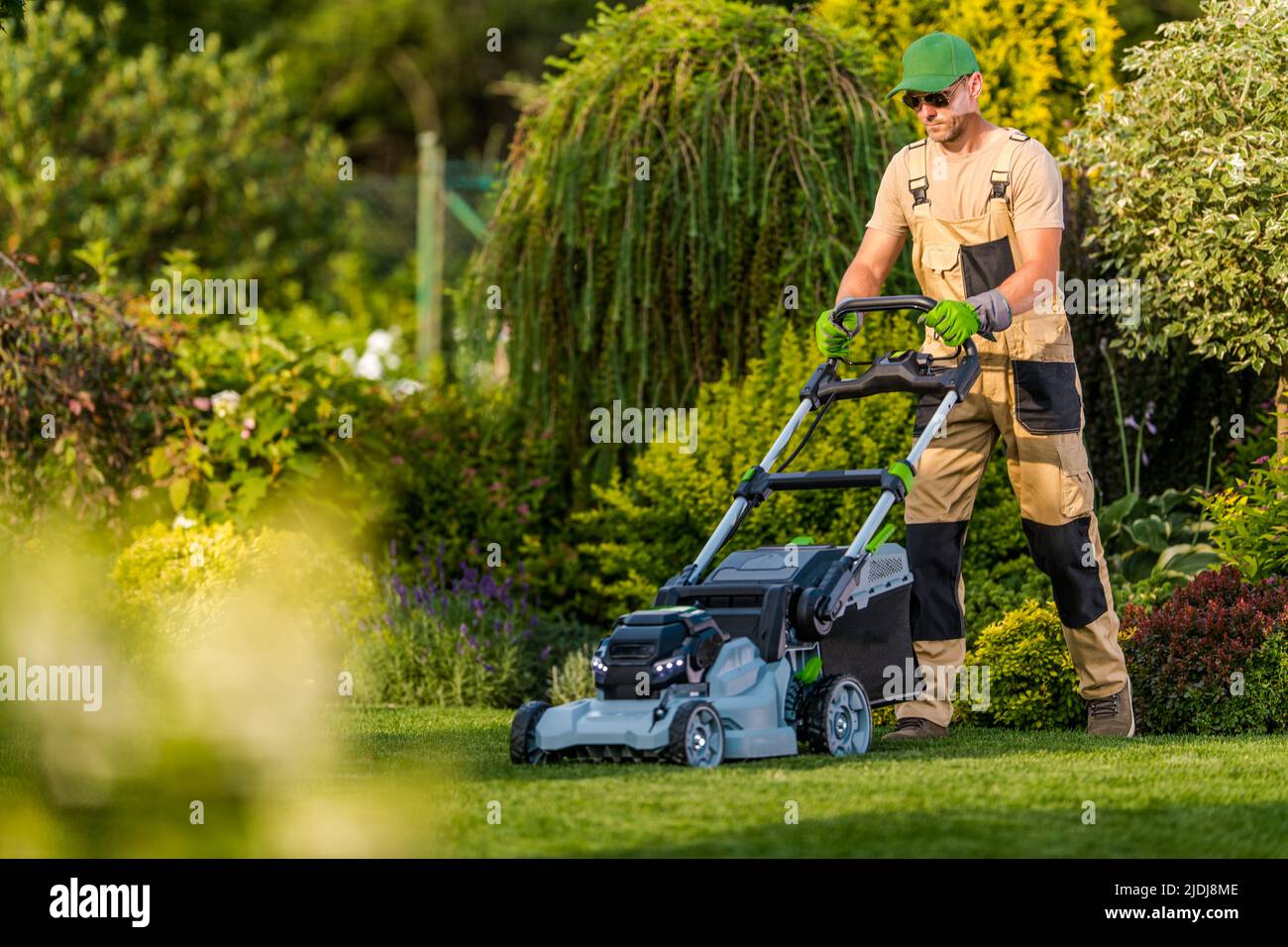 Garden Maintenance Professional Services. Caucasian Gardener Taking Care of the Grass Using Riding Lawn Mower During Summer Season. Stock Photo