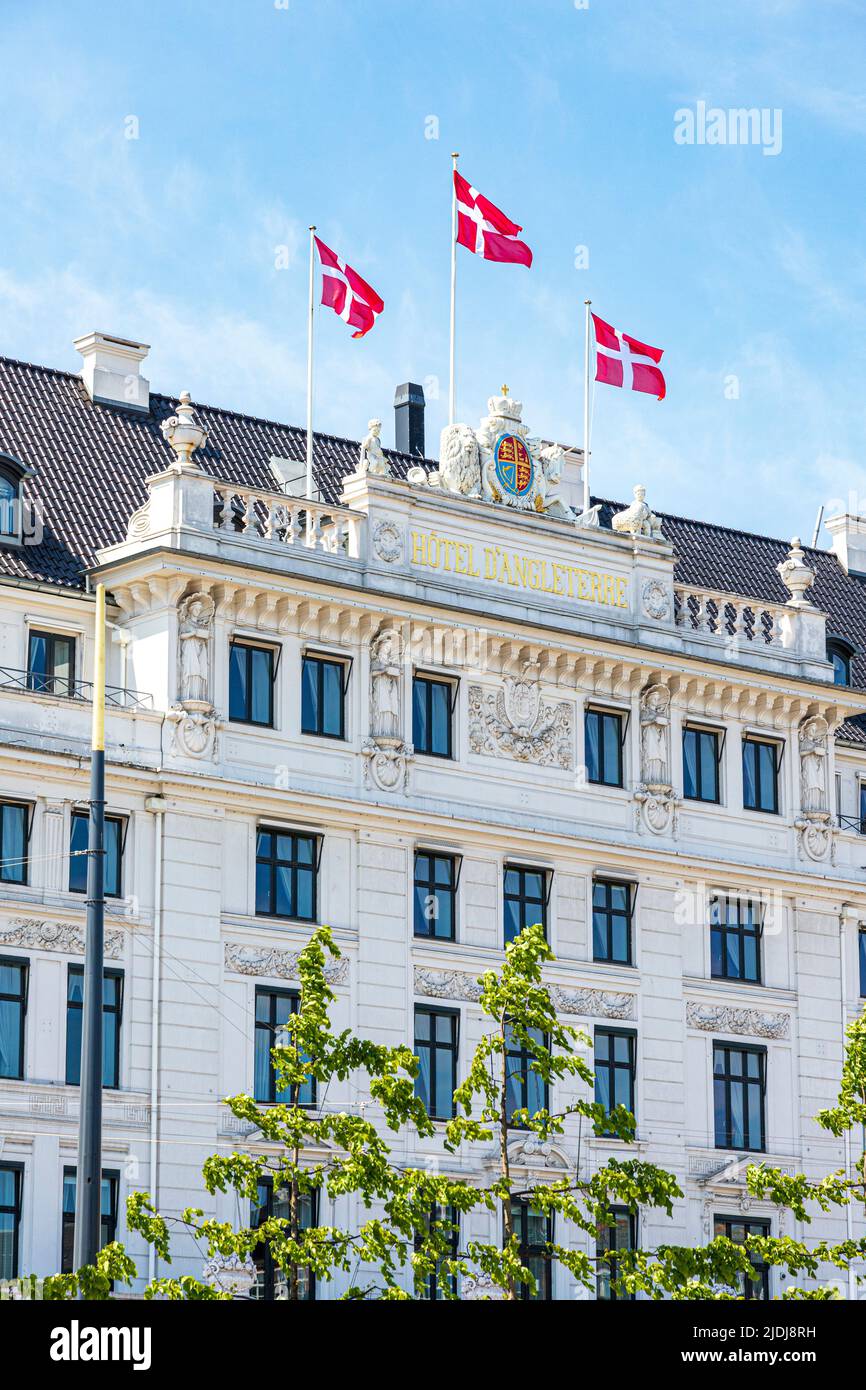 Danish flags flying over the 1755 Hotel D'Angleterre in Kongens Nytorv (The King's New Square) in Copenhagen, Denmark. Stock Photo