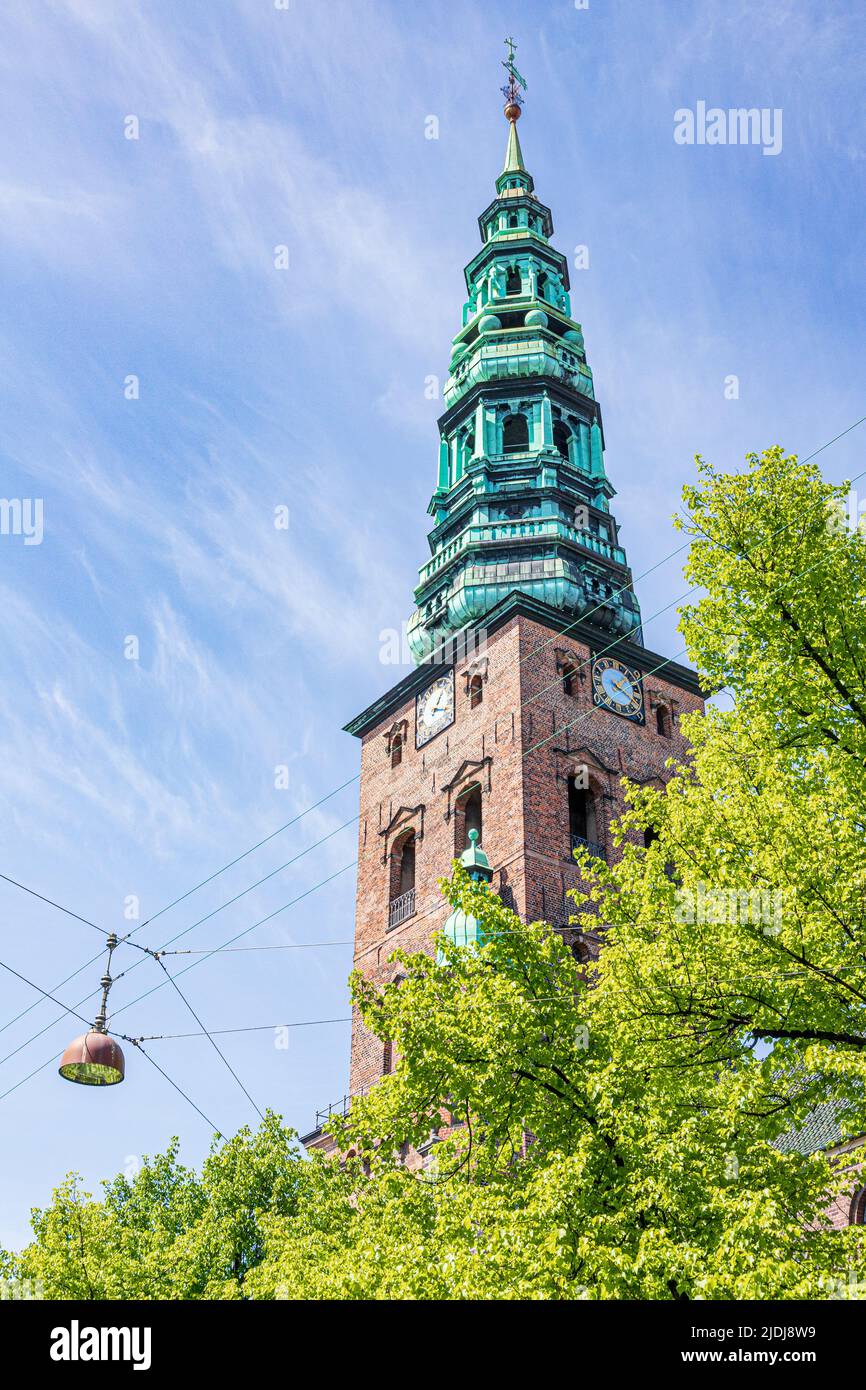 Looking up at the old tower and spire of the Nikolaj Contemporary Art Center (Kunsthallen Nikolaj) in Copenhagen, Denmark. Stock Photo