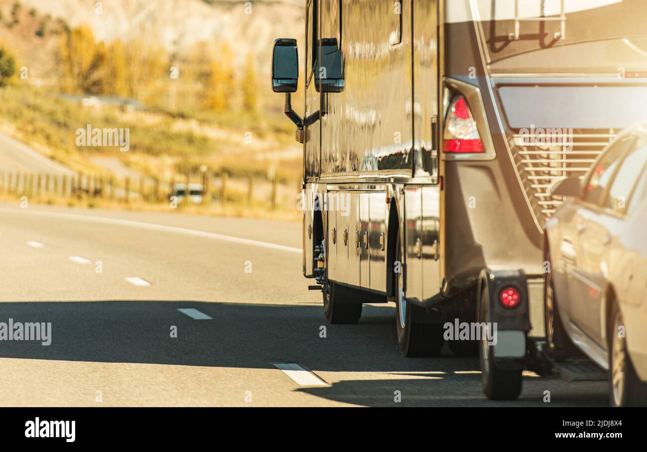 Class A Diesel Pusher Recreational Vehicle. RV Motor Coach with Pull Vehicle on a Highway. Travel in a Motorhome. Stock Photo