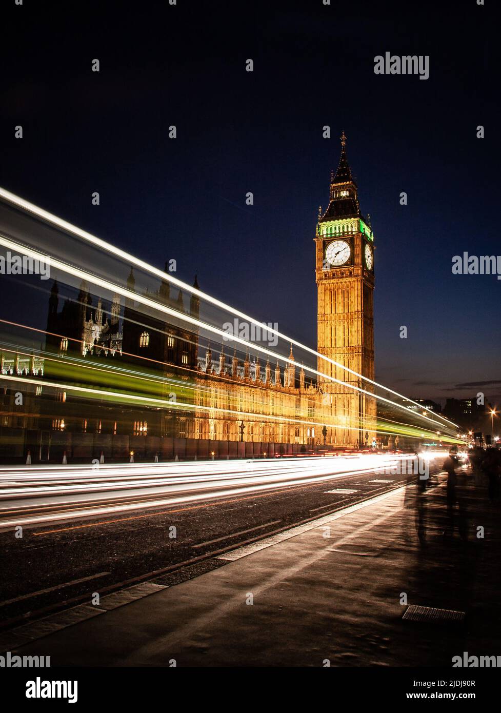 Big Ben at night, London. Long exposure traffic streaming by the famous Big Ben and Houses of Parliament landmarks. Stock Photo