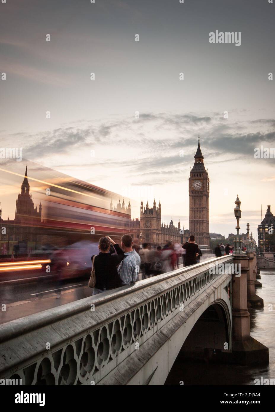 London City Break. Tourists taking a moment to capture a view of Westminster Bridge and London's famous Big Ben landmark clock tower. Stock Photo