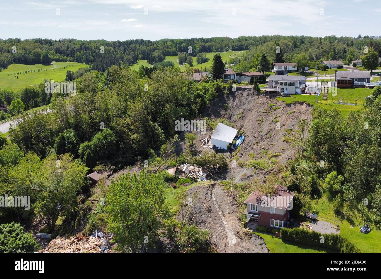 A building lies at the bottom of a landslide which destroyed a house