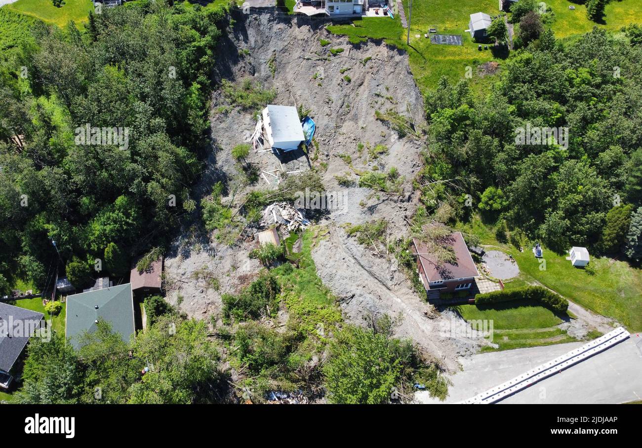 A building lies at the bottom of a landslide which destroyed a house