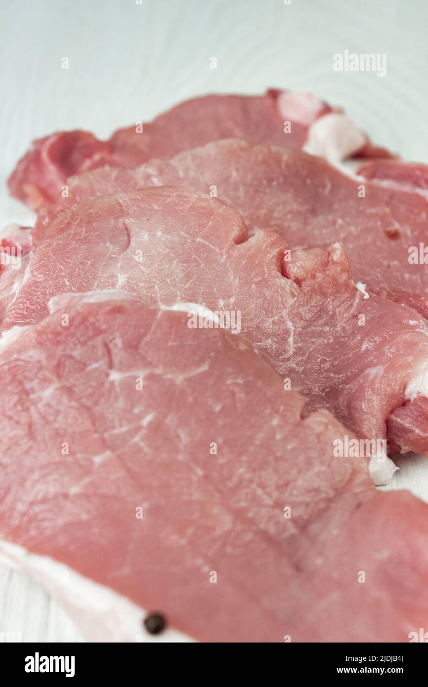 Elevated view of raw meat steaks and spices on white background. Fillet