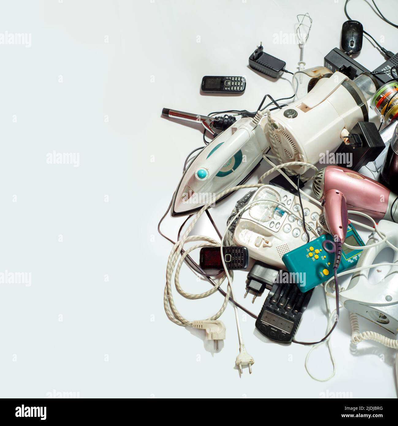Lots of old electrical appliances for recycling e-waste. Sustainable living concept. Space for text on white background Stock Photo