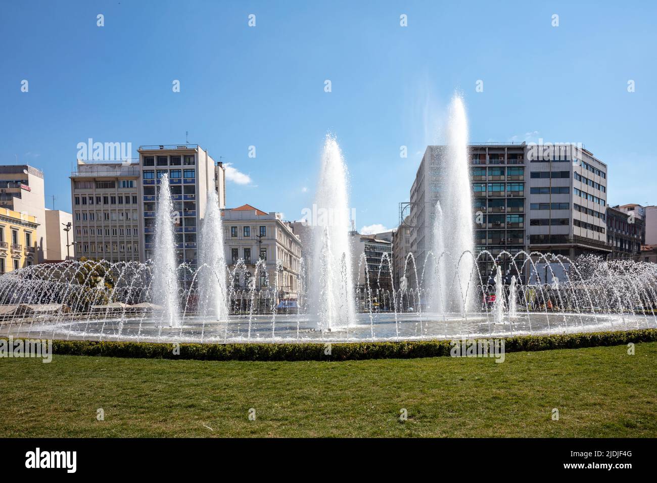 Omonoia Square, New water fountain in Athens, Greece. Omonia is a round plaza in the city center, sunny day, blue sky. Stock Photo