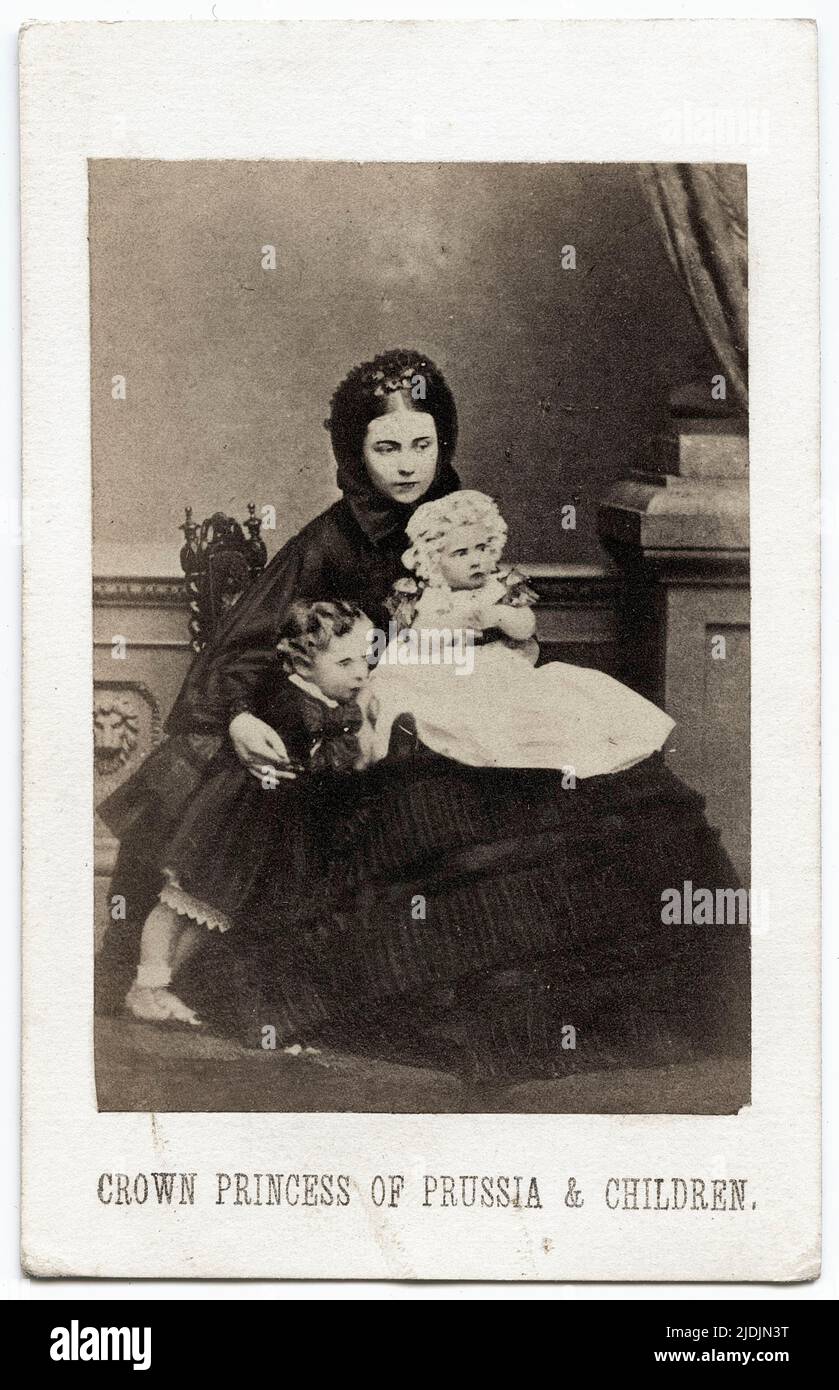 Full length portrait of Crown Princess Victoria and her children, July 1861. From left to right, Prince Wilhelm (1859 - 1941), Victoria, Crown Princess of Prussia (1840 - 1901) and Princess Charlotte (1860 - 1919) (on lap). Photography by John Jabez Edwin Mayall (1813 - 1901). Stock Photo