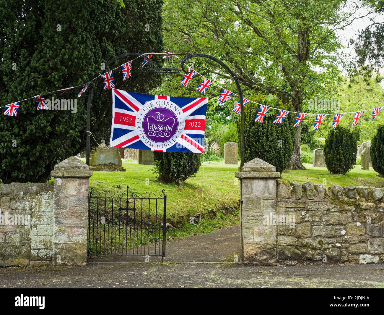 Flag and bunting in celebration of the platinum jubilee of Queen Elizabeth the second in a Northumberland village. Stock Photo