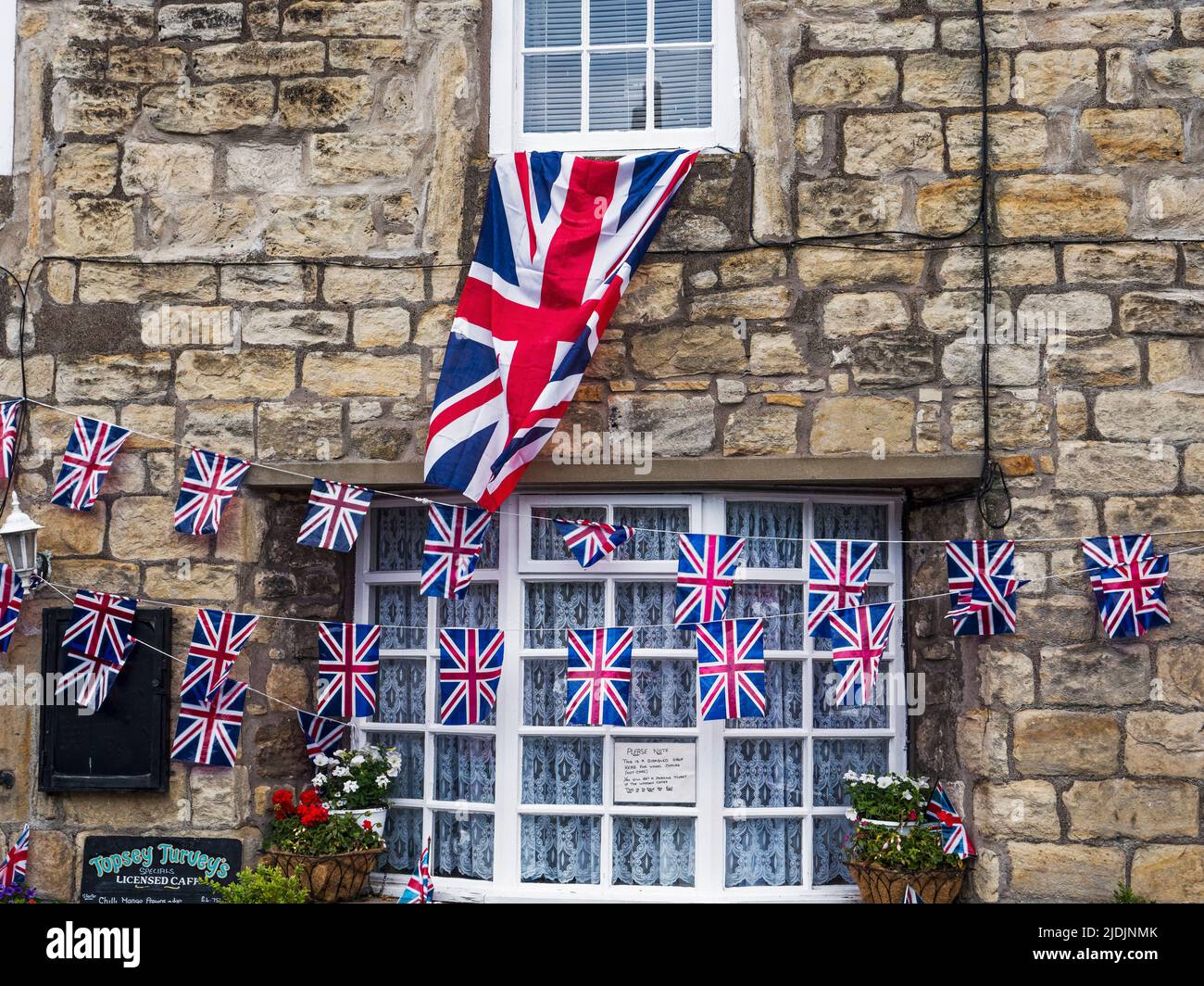 Flag and bunting in celebration of the platinum jubilee of Queen Elizabeth the second in a Northumberland village. Stock Photo