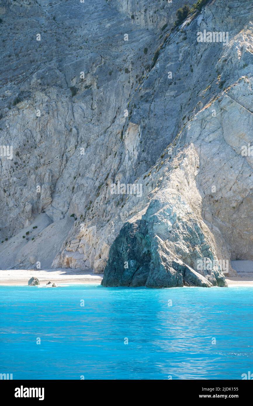 Beautiful wild Mediterranean pebble beach under a large massive rock Stock Photo