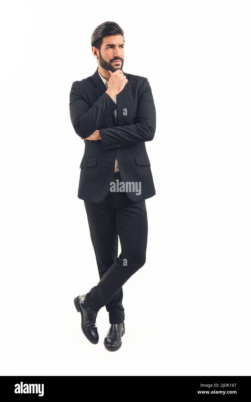 young latin businessman in black classic suit stands looking away. High quality photo Stock Photo