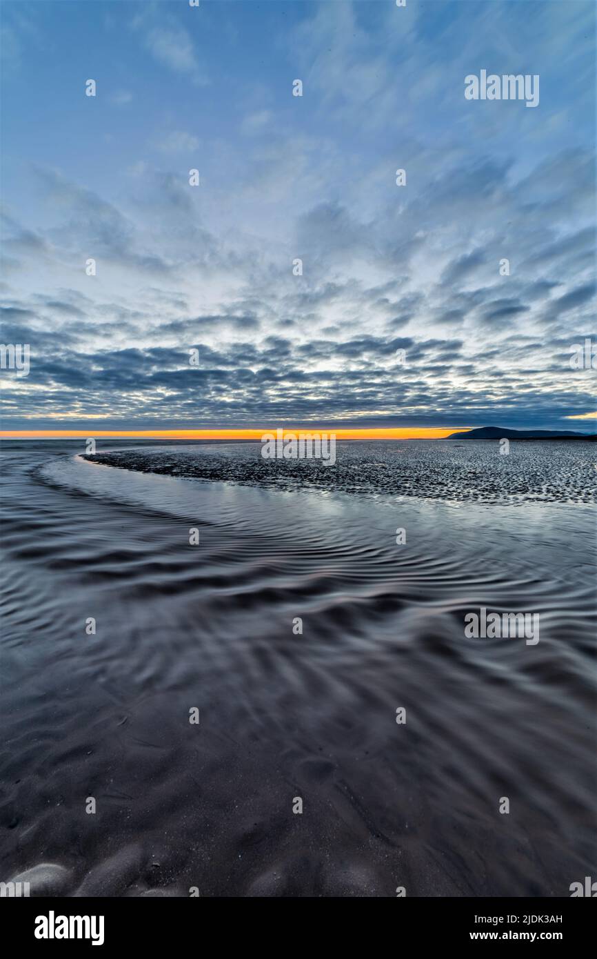 Walney Island, Cumbria, UK. 21st June 2022. UK Weather. Summer solstice sunset from Sandy gap, Walney Island on the Cumbrian Coast, view towards the distant Black Combe. Credit:greenburn/Alamy Live News. Stock Photo
