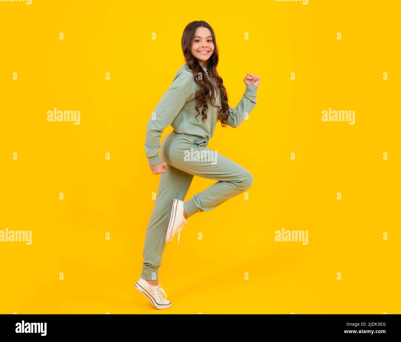 Beautiful teenager child girl in a sports suit, tracksuits. The girl in street sport clothing