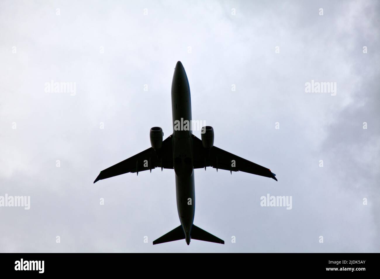 looking up at a plane above just after taking off from Manchester airport, UK Stock Photo